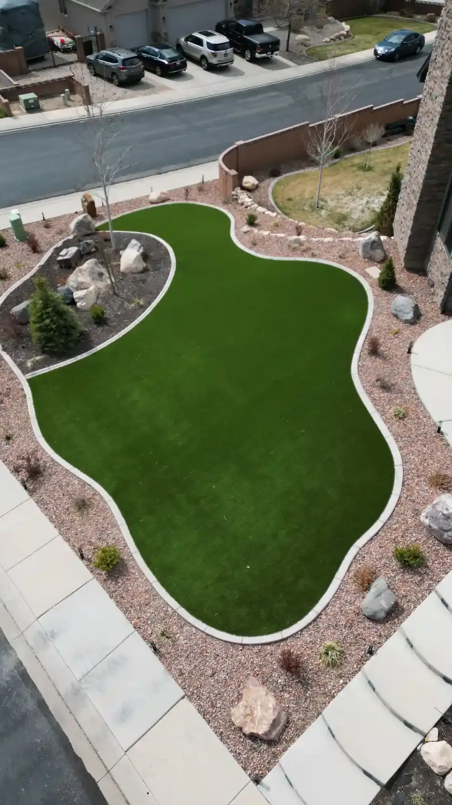 Aerial view of a curved artificial turf lawn framed by rock landscaping