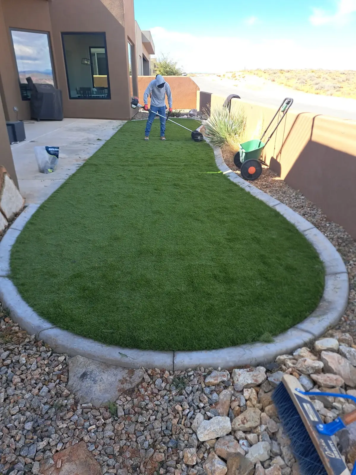 Oval turf lawn surrounded by concrete curbing