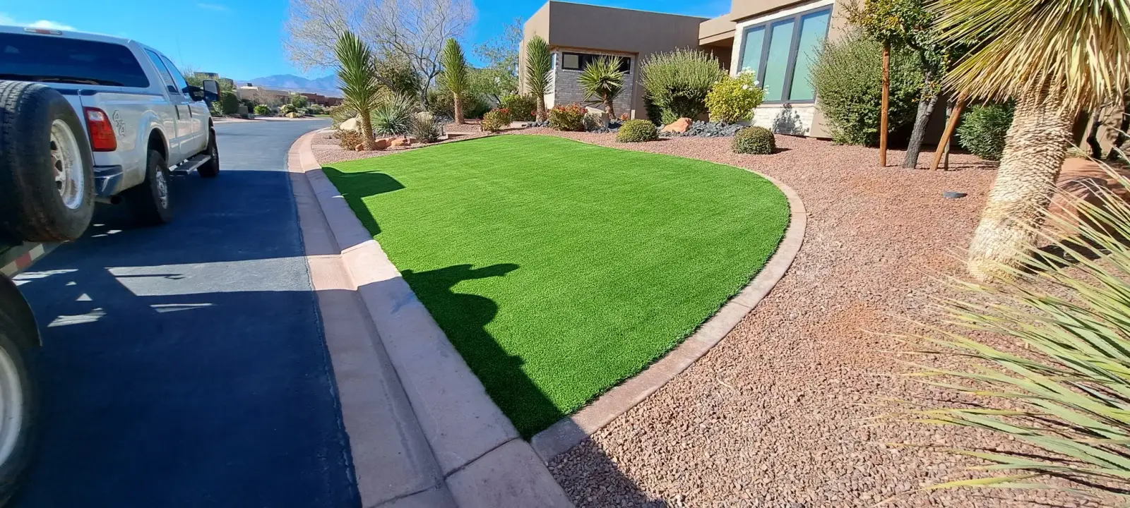 Curved turf lawn in front of a desert home